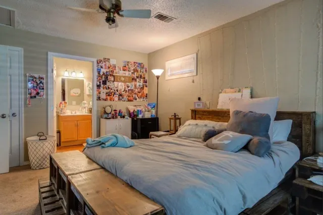 a bedroom with a bed a couch and a chandelier