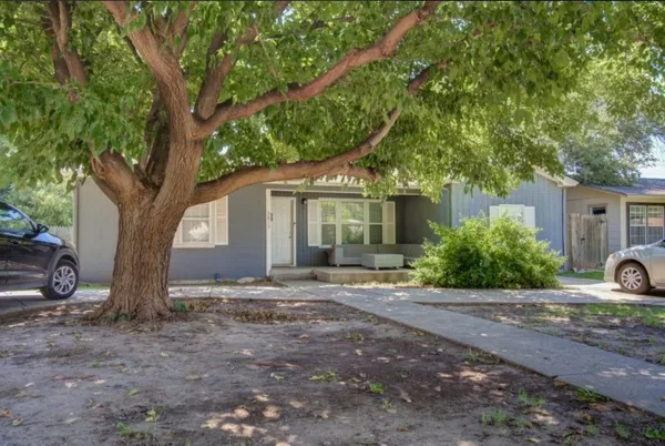 a view of a house with backyard and a tree