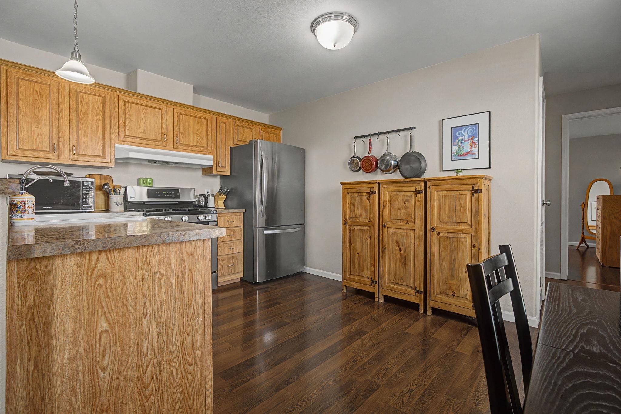 3251 E Road, Unit 72 Clifton, CO 81520 - Photo 11 of 25 a kitchen with stainless steel appliances granite countertop a refrigerator a stove a sink dishwasher and wooden cabinets with wooden floor