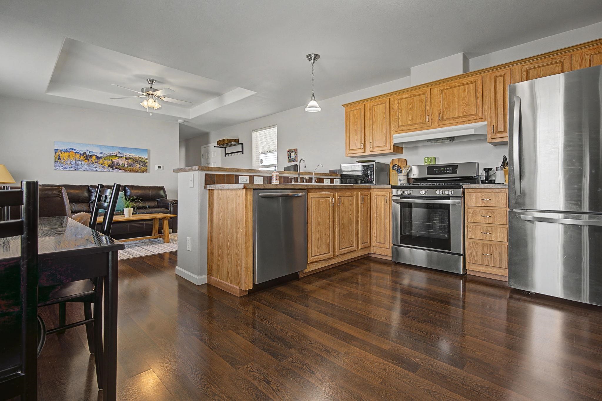 3251 E Road, Unit 72 Clifton, CO 81520 - Photo 9 of 25 a kitchen with stainless steel appliances granite countertop a refrigerator a stove top oven a sink dishwasher and a refrigerator with wooden floor
