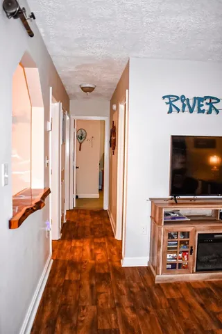 a view of a livingroom with wooden floor and a flat screen tv