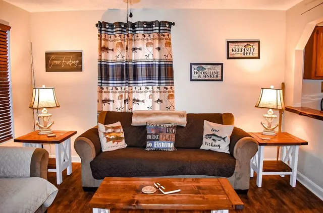 a living room with furniture a flat screen tv and kitchen view