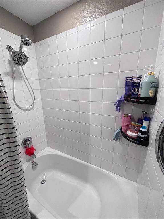 279 Bergamot Loop Davenport, FL 33837 - Photo 20 of 38 a bathroom with a tub sink and shower curtain