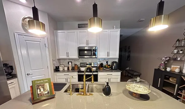 a kitchen with sink refrigerator and microwave