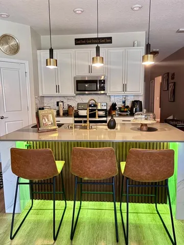 a kitchen with a table chairs stove and refrigerator