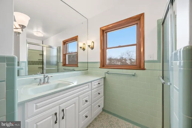 a bathroom with a granite countertop sink a mirror and a window