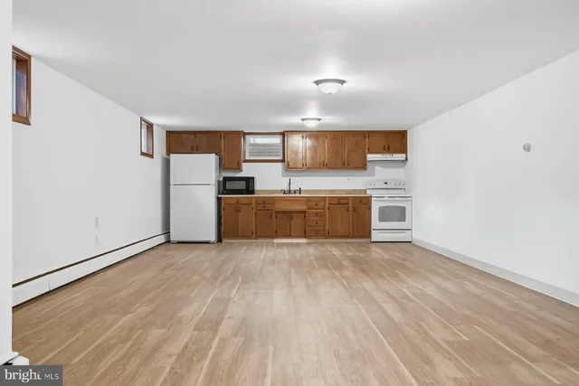 a view of a kitchen with wooden floor and electronic appliances