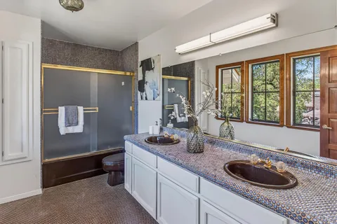 a bathroom with a granite countertop sink a toilet and a large mirror