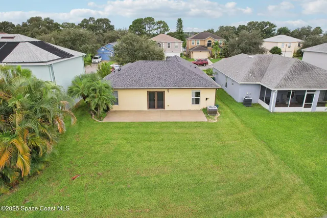 an aerial view of residential houses with outdoor space and trees