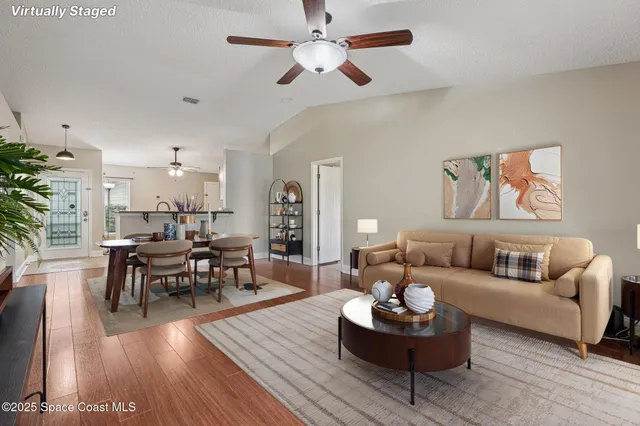 a living room with furniture and a wooden floor