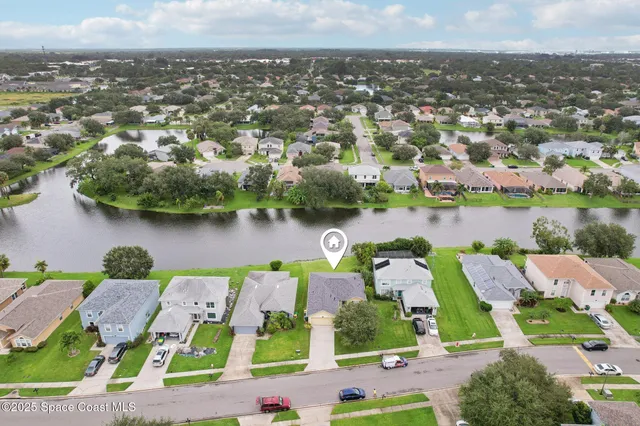 an aerial view of residential houses with outdoor space and lake view