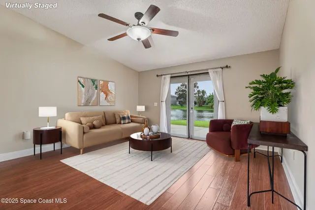 a living room with furniture potted plant and a large window