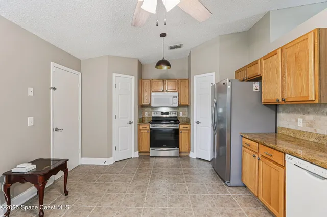 a kitchen with stainless steel appliances granite countertop a refrigerator and a stove top oven