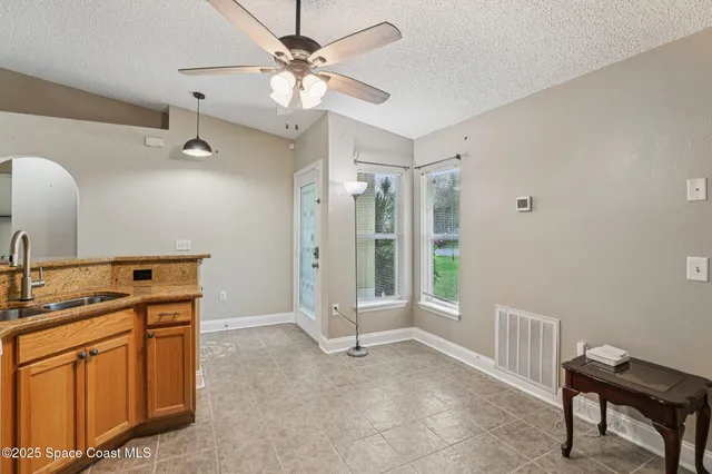 a view of a kitchen with fridge and wooden floor