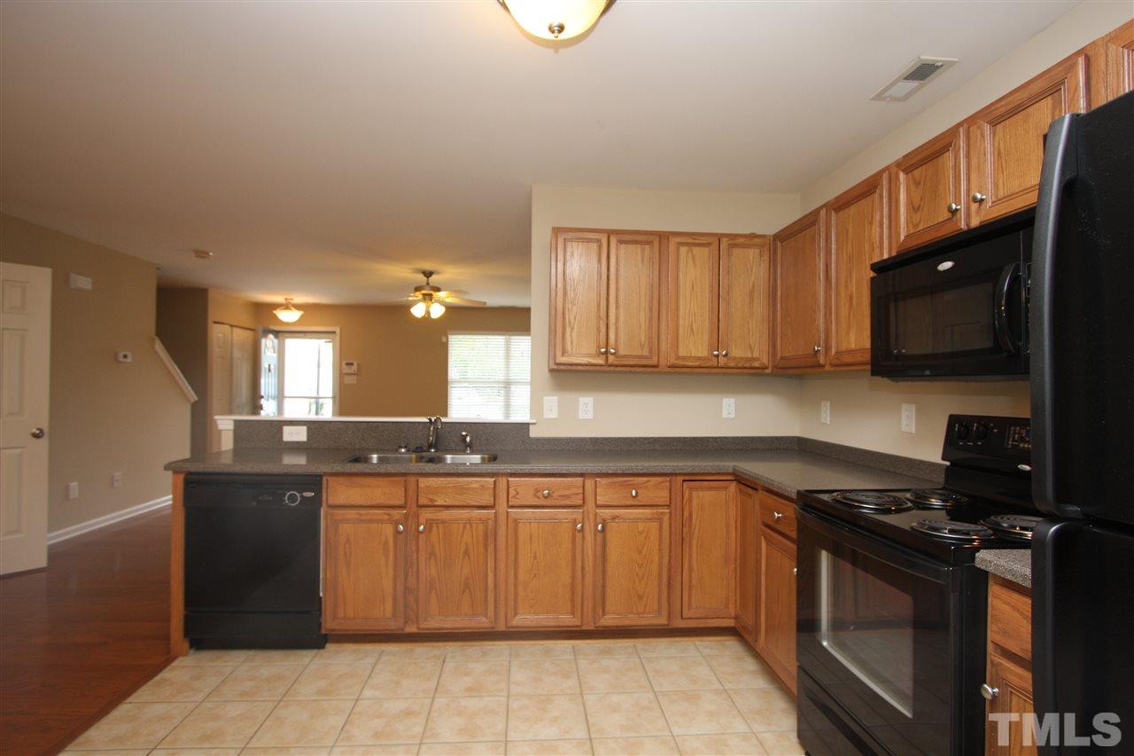 8902 Thornton Garden Lane Raleigh, NC 27616 - Photo 12 of 23 a kitchen with stainless steel appliances granite countertop a stove a sink and a microwave