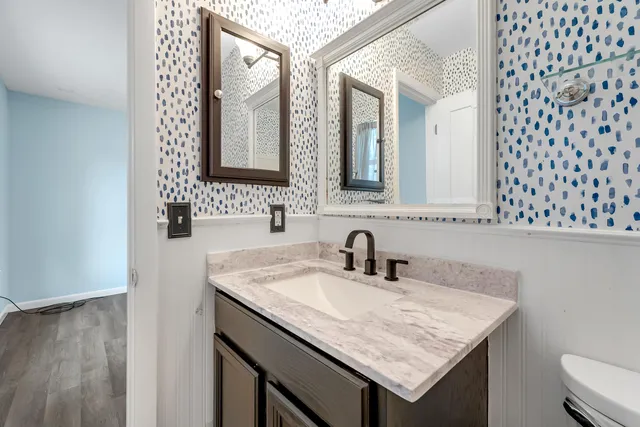a bathroom with a granite countertop sink and a mirror