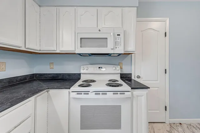 a white stove top oven sitting inside of a kitchen