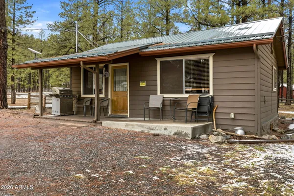 a view of house with backyard outdoor seating and floor to ceiling window