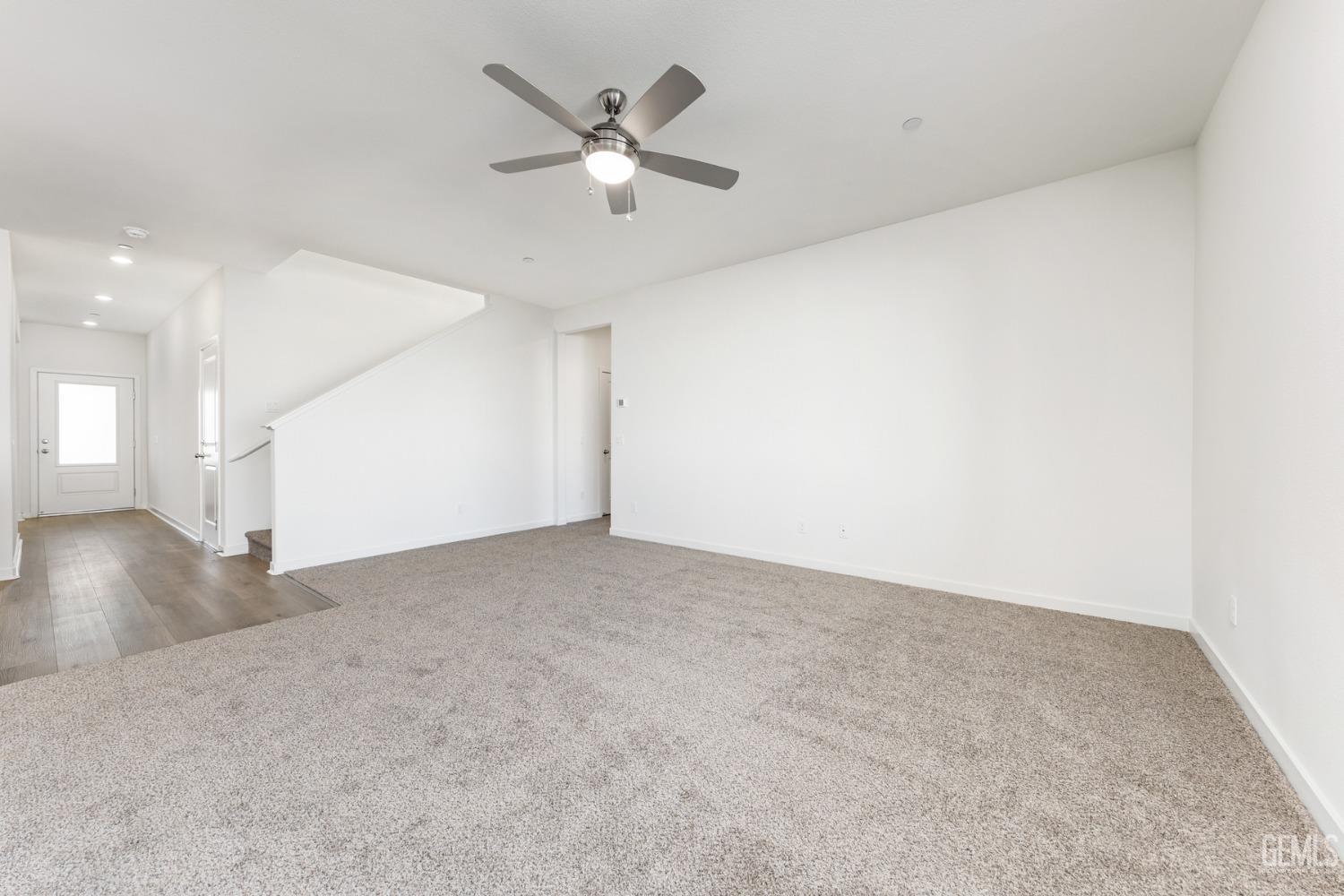 Undisclosed Address Bakersfield, CA 93313 - Photo 2 of 12 an empty room with a white walls and chandelier fan
