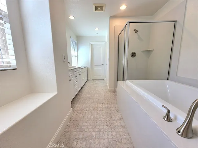 a bathroom with a tub a sink and mirrors