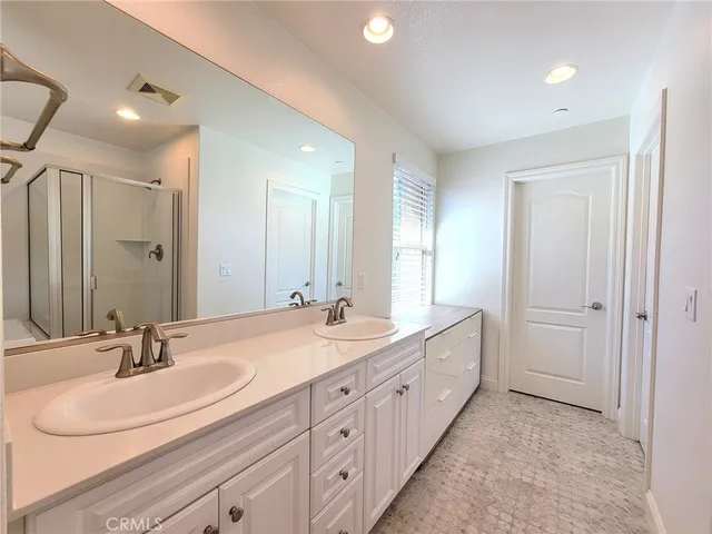 a bathroom with double sink and a mirror
