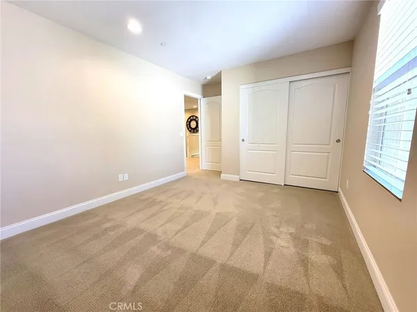 an empty room with windows and closet