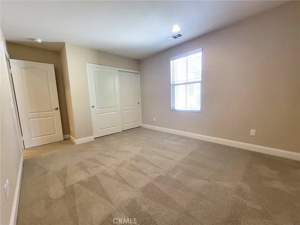 an empty room with windows and closet