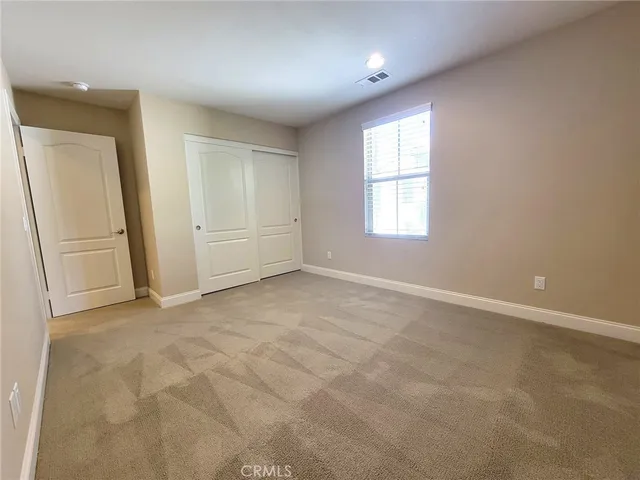 an empty room with windows and closet