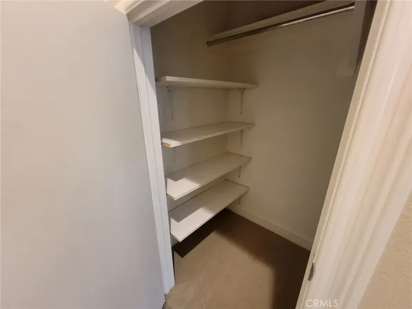 a view of walk in closet with empty racks