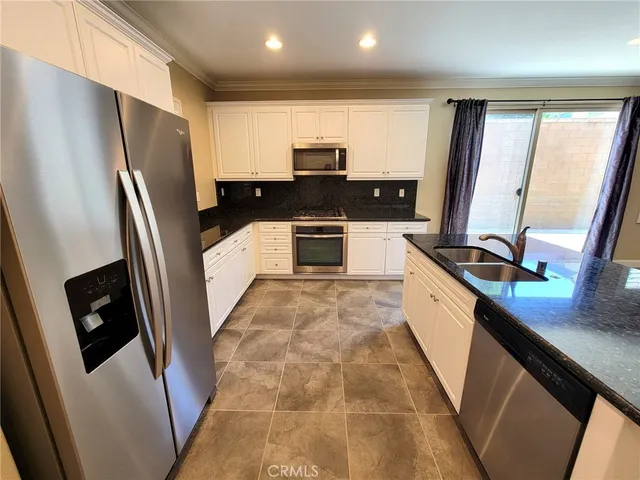 a kitchen with stainless steel appliances a refrigerator sink and stove