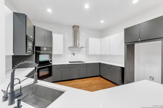 a kitchen with stainless steel appliances granite countertop a sink stove and refrigerator