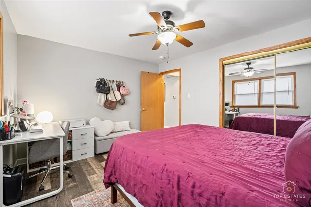 a bedroom with a bed a dresser and a large window