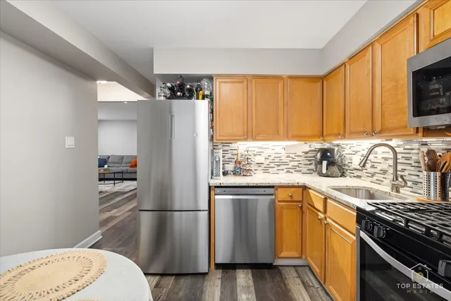 a kitchen with stainless steel appliances granite countertop a refrigerator sink and stove