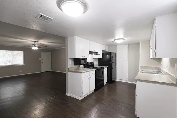a kitchen with stove cabinets and wooden floor