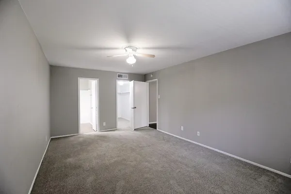 a view of an empty room with a chandelier fan