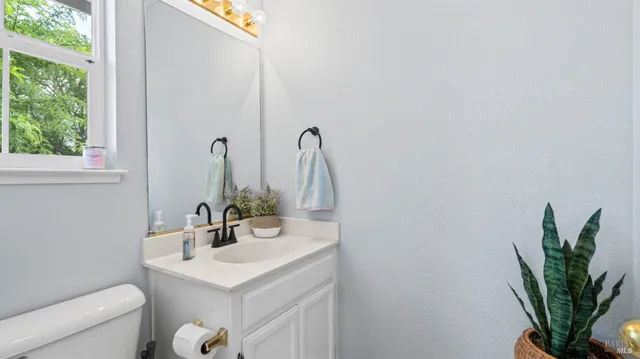 a bathroom with a sink a toilet and a window