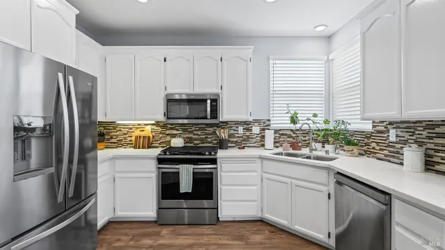 a kitchen with white cabinets and stainless steel appliances
