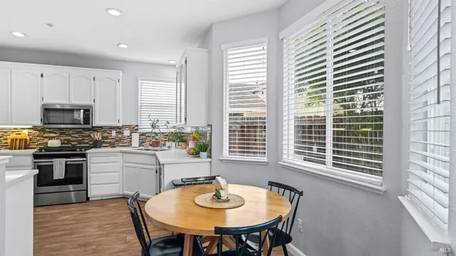 a kitchen with a table chairs sink and cabinets