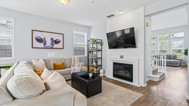 a living room with furniture a flat screen tv and a fireplace