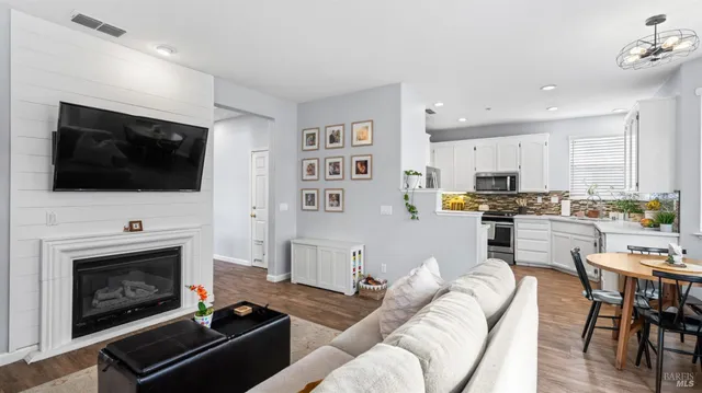 a living room with furniture a flat screen tv and a fireplace
