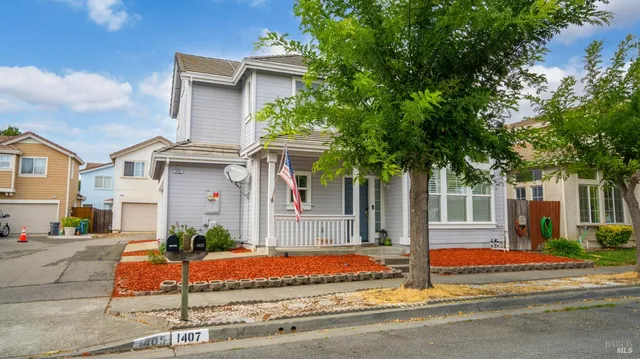 a view of a white house with large windows and a table and chairs