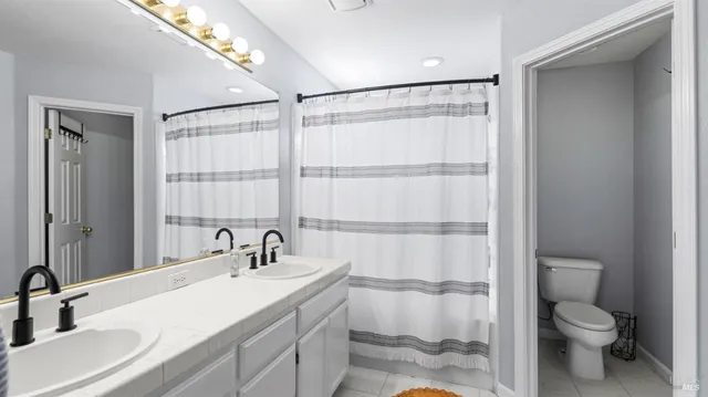 a bathroom with a sink toilet a mirror and shower