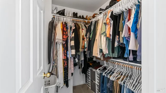 a view of walk in closet with clothes