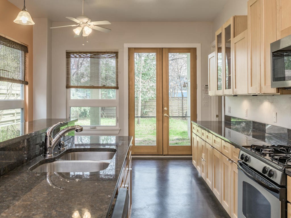 3815 Red River Street, Unit B Austin, TX 78751 - Photo 1 of 1 a large kitchen with kitchen island a large window a sink and stainless steel appliances