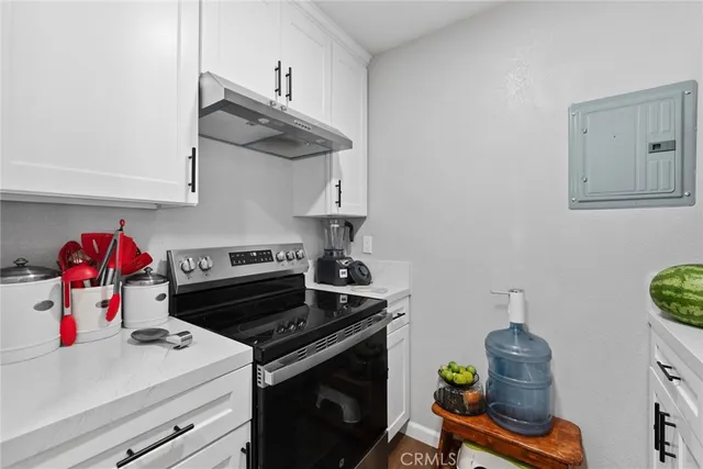 a kitchen with a stove and a wooden floor