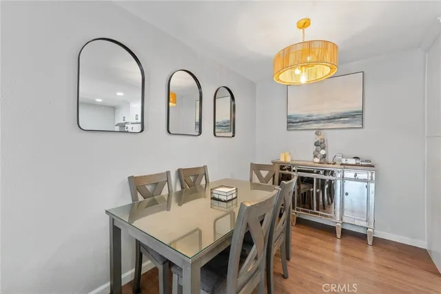a view of a dining room and kitchen with furniture wooden floor and chandelier