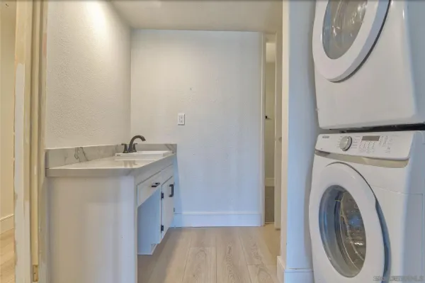 a bathroom with a sink a mirror and a washer dryer