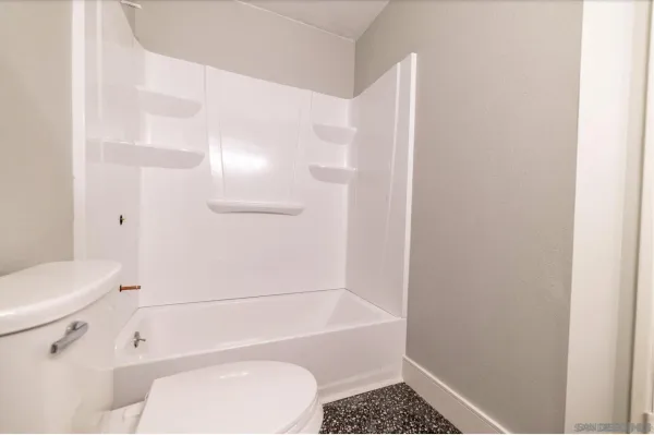 a bathroom with a toilet and a shower