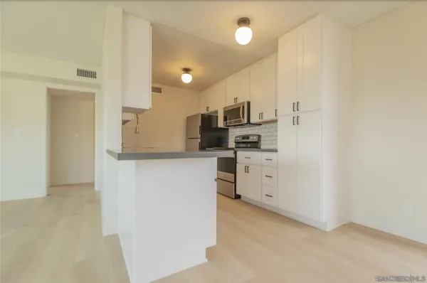 a view of a kitchen with white cabinets