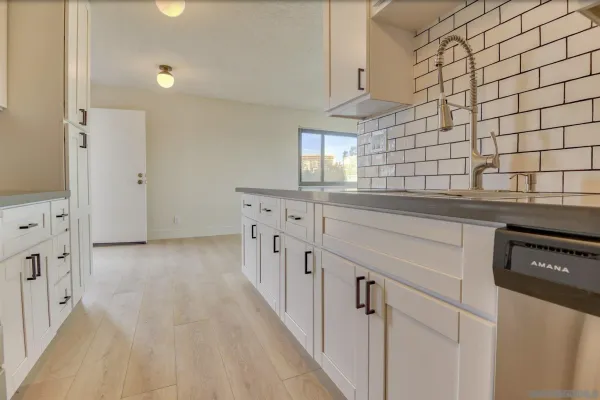a kitchen with granite countertop a sink and cabinets